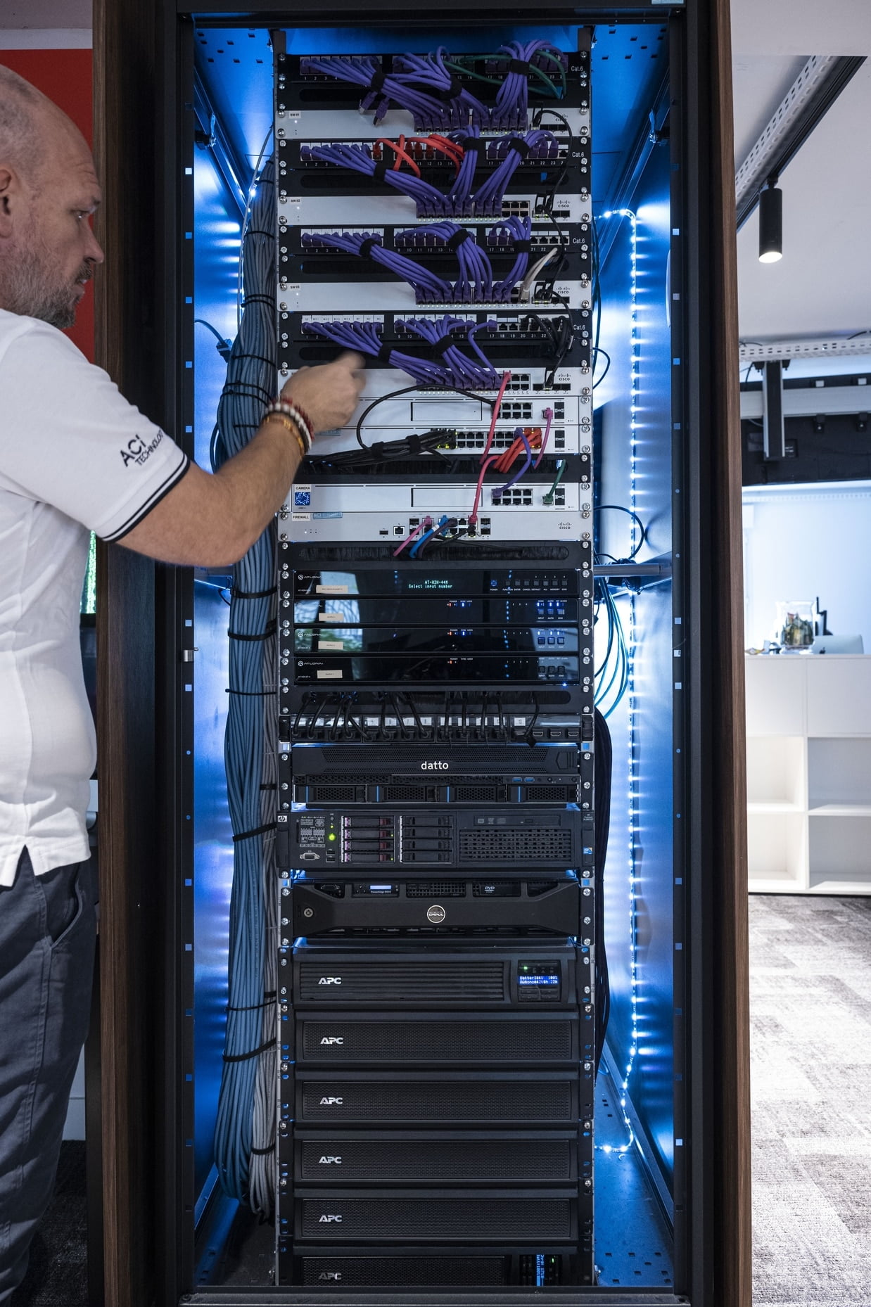 Technicien ACI Technology intervenant sur une baie informatique pour la maintenance et la sécurisation des serveurs