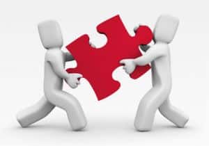 Collaboration entre équipes IT symbolisée par l’assemblage d’une pièce de puzzle