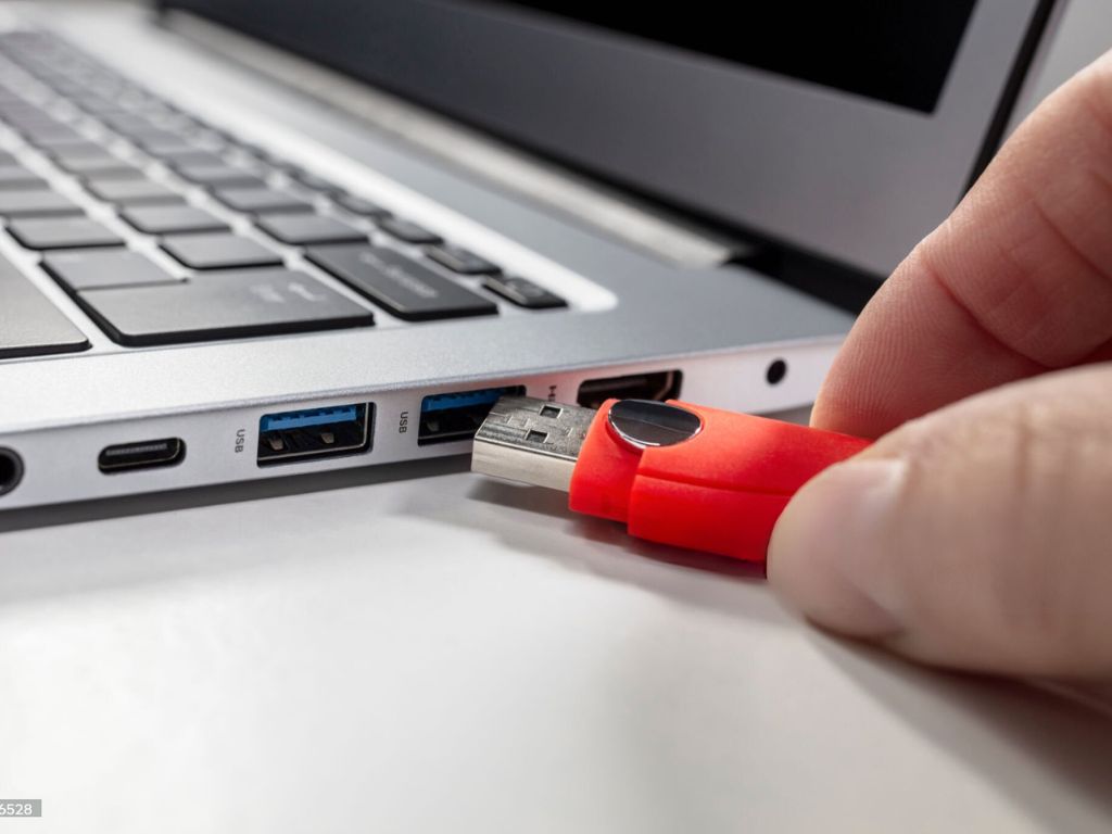 Image représentant une clé USB insérée dans le port USB d'un ordinateur portable