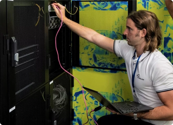 Technicien ACI Technology réalisant une intervention de maintenance informatique sur une baie serveur avec ordinateur portable