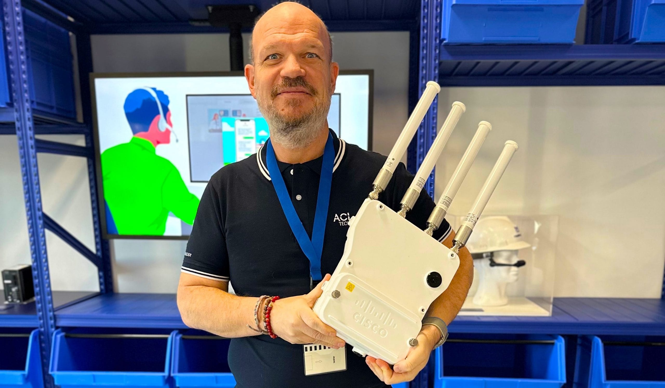 Ingénieur système et réseau d'ACI Technology avec une borne wifi pour entreprise